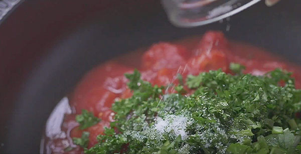 タジン鍋を火にかけ、トマトソースの材料を投入し、泡が出るまで加熱する。